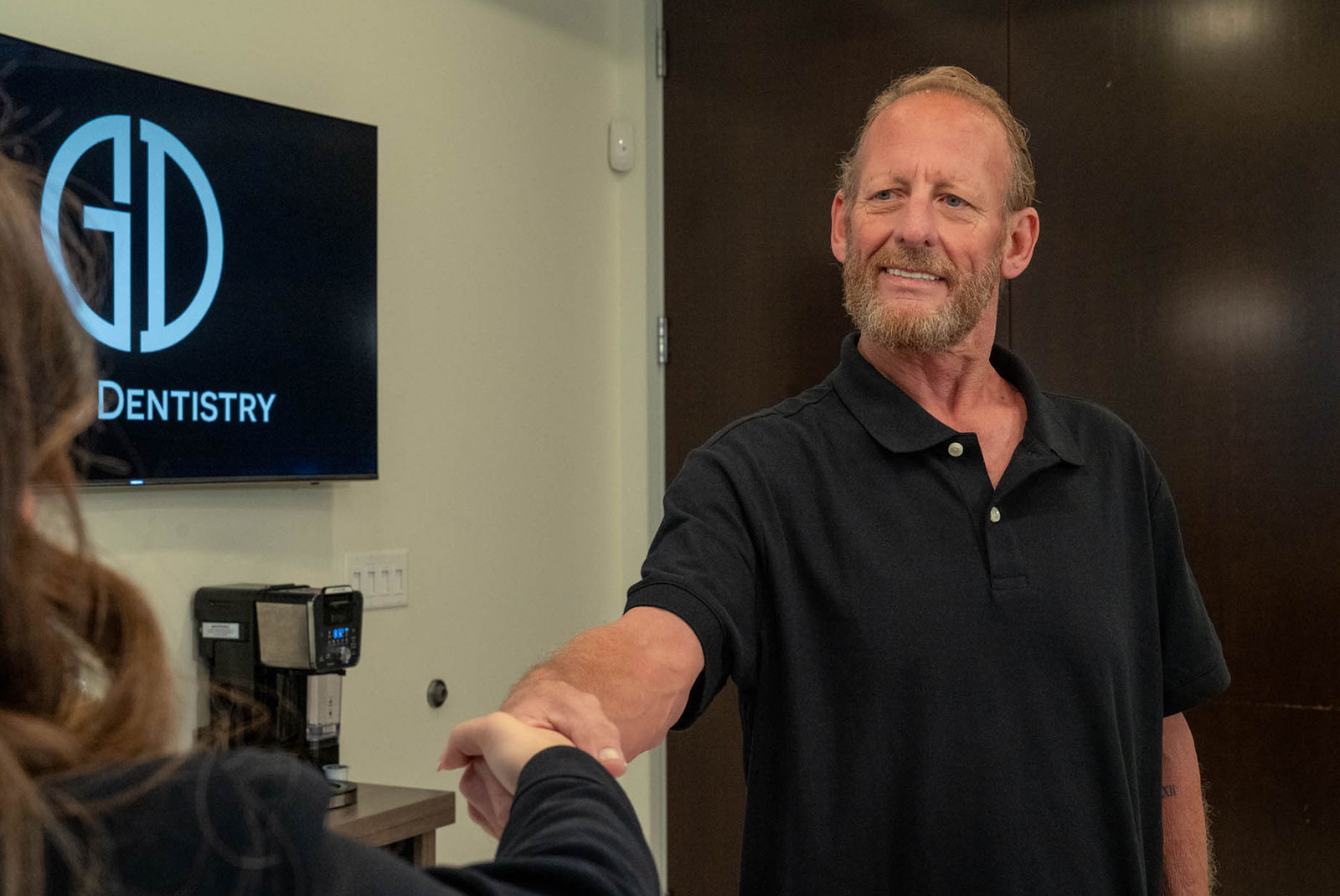 man shaking hands at front desk